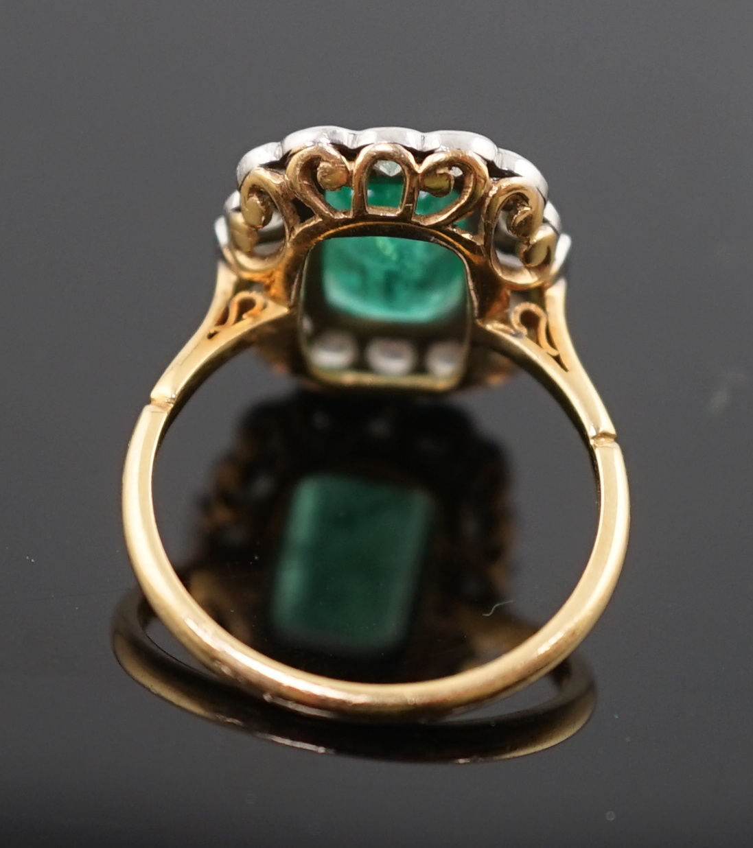 An Art Deco style gold, emerald and diamond set oval cluster ring